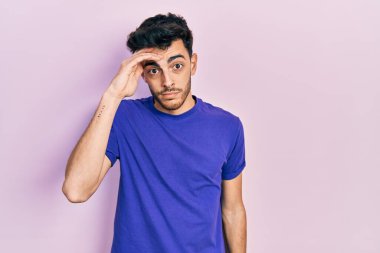 Gündelik tişört giyen genç İspanyol adam alında bir sorun olduğu için endişeli ve stresli, gergin ve bunalımda. 