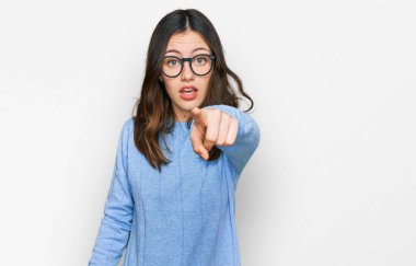 Gayri resmi giyinen ve gözlük takan genç ve güzel bir kadın kameraya kızgın ve sinirli olduğunu gösteriyor. 