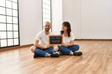 Yeni evimizde yeni ev tahtamızı tutarken mutlu gülümseyen İspanyol çift..