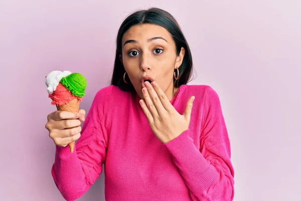若いヒスパニック系の女性手で口をカバーアイスクリームを保持し ショックを受け ミスを恐れている 驚きの表情 — ストック写真
