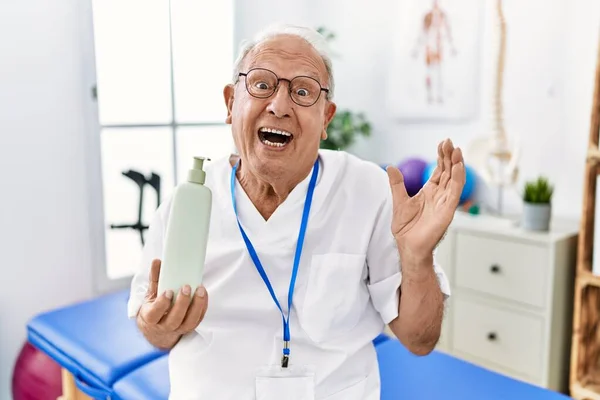 Senior Sjukgymnastik Man Som Håller Massage Kroppslotion Skriker Stolt Firar — Stockfoto