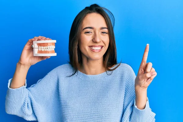 Menina Hispânica Jovem Segurando Dentadura Sorrindo Com Uma Ideia Pergunta — Fotografia de Stock