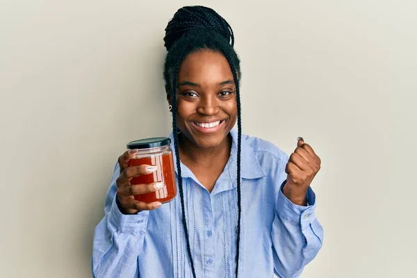 Mujer Afroamericana Con Cabello Trenzado Sosteniendo Mermelada Gritando Orgullosa Celebrando —  Fotos de Stock