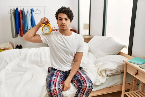 Junger Hispanischer Mann Mit Wecker Sitzt Auf Dem Schlafzimmertisch Und — Stockfoto