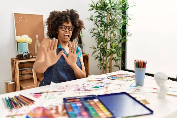 美丽动人的非洲裔美国女人 在艺术工作室里画着非洲裔的头发 害怕而害怕 用恐惧的表情停止了举手表决 震惊地大叫 恐慌概念 — 图库照片