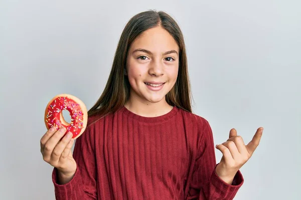 Hermosa Niña Morena Sosteniendo Sabrosa Rosquilla Colorida Sonriendo Feliz Señalando — Foto de Stock