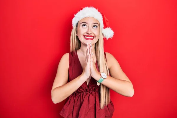 Genç Sarışın Kız Noel Şapkası Takıyor Elleriyle Yalvarıyor Dua Ediyor — Stok fotoğraf
