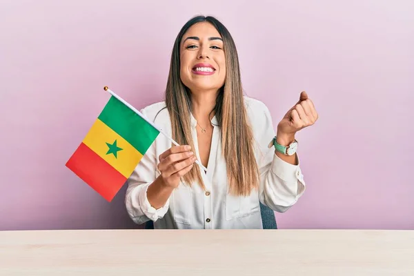 Mujer Hispana Joven Sosteniendo Bandera Senegal Sentada Mesa Gritando Orgullosa —  Fotos de Stock