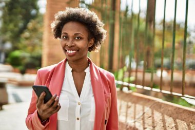 Güzel iş kadını afro saçlı Afro-Amerikan kadın mutlu ve kendinden emin bir şekilde gülümsüyor.