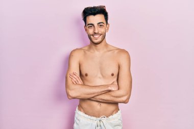 Mayo giyen genç İspanyol adam kollarını kavuşturup kameraya bakarken gülümsüyor. pozitif kişi. 