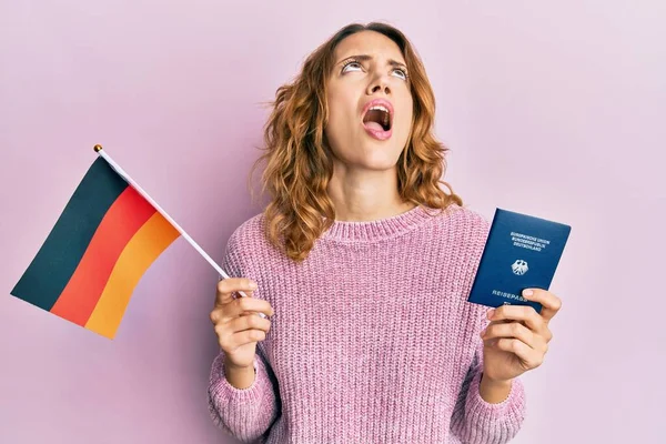 Joven Mujer Caucásica Sosteniendo Bandera Alemania Pasaporte Enojado Loco Gritando —  Fotos de Stock