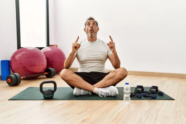 Hombre Hispano Mediana Edad Sentado Una Colchoneta Entrenamiento Gimnasio Asombrado —  Fotos de Stock