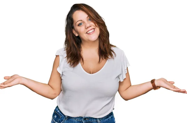 若いプラスサイズの女性は両手を開いて手のひらを示す笑顔カジュアルな白いTシャツを身に着けています プレゼンテーションと広告の比較とバランス — ストック写真