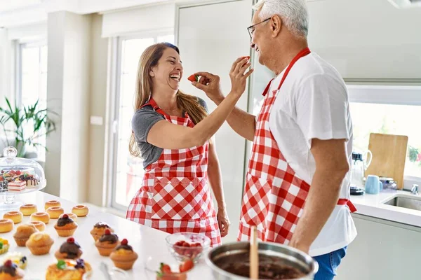 Casal Hispânico Meia Idade Sorrindo Feliz Dando Morango Outro Cozinha — Fotografia de Stock