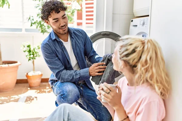 Jovem Casal Sorrindo Feliz Beber Café Enquanto Lavava Roupa Casa — Fotografia de Stock