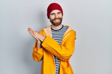 Sakallı, sarı yağmurluklu beyaz adam alkışlıyor ve alkışlıyor. Mutlu ve neşeli, gururlu eller bir arada. 