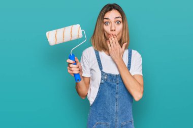 Sarışın genç bir kız, patenci boyacı tutarak ağzını eliyle kapatıyor, şok geçiriyor ve hata yapmaktan korkuyor. şaşırmış ifade 