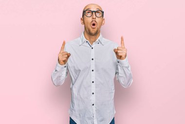 Sakallı, iş gömleği ve gözlüklü kel adam şaşırmış ve şaşırmış bir şekilde yukarı baktı ve parmaklarıyla işaret ederek kollarını kaldırdı.. 