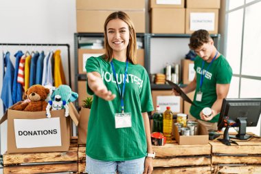 Bağış standında gönüllü tişört giyen genç sarışın kız gülümseyerek avuç içi yardım ve kabullenme teklif ediyor.. 