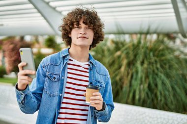 Genç İspanyol adam şehirde akıllı telefon kullanıyor.