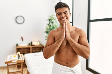 İspanyol asıllı genç adam kaplıcada üstsüz duruyor. Elleriyle birlikte dua ediyor. Affedilmek için dua ediyor.. 