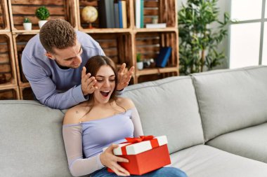 Genç adam evde doğum günü hediyesiyle kız arkadaşına sürpriz yapıyor..