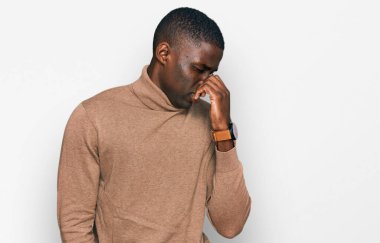 Genç Afro-Amerikan adam, günlük kışlık süveter giyiyor pis ve iğrenç bir koku alıyor, dayanılmaz bir koku, parmakları burnunda nefesini tutuyor. Kötü kokuyor. 