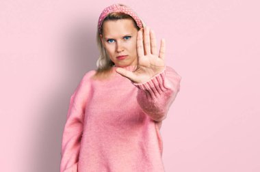 Günlük kıyafetler giyen beyaz bir kadın avucunun içi gibi şarkı söylemeyi kesiyor. Yüzünde olumsuz ve ciddi bir jest olan uyarı ifadesi. 