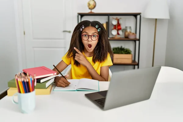 Young African American Girl Doing Homework Home Surprised Pointing Finger —  Fotos de Stock