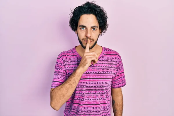 英俊的惊慌失措的男人穿着休闲的粉色T恤 请求安静 手指放在嘴唇上 沉默和秘密概念 — 图库照片