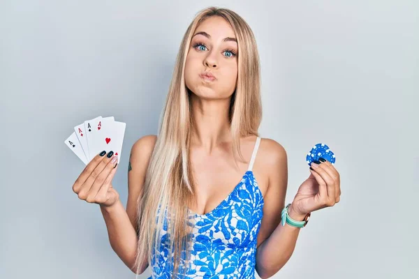 Jovem Bela Mulher Caucasiana Segurando Cartas Poker Fichas Soprando Bochechas — Fotografia de Stock