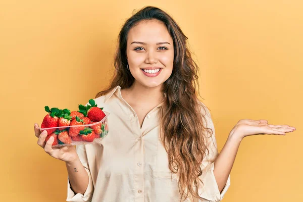 Joven Chica Hispana Sosteniendo Fresas Sonriente Alegre Presentando Señalando Con —  Fotos de Stock