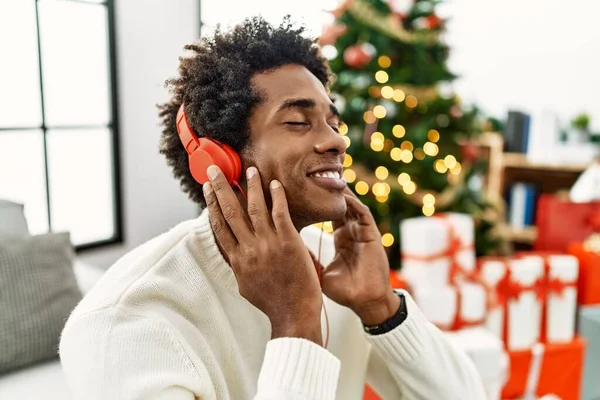 Jovem Afro Americano Usando Fones Ouvido Sentados Árvore Natal Casa — Fotografia de Stock