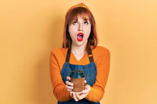 Rothaarige Junge Frau Kellnerschürze Mit Einer Tasse Kaffee Zum Mitnehmen — Stockfoto