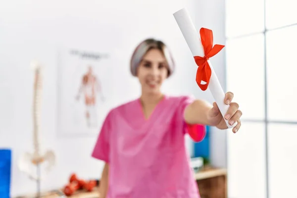 Joven Fisioterapeuta Caucásica Sonriendo Feliz Sosteniendo Diploma Clínica —  Fotos de Stock