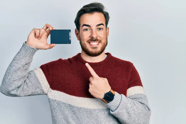 Handsome Caucasian Man Beard Holding Ssd Memory Smiling Happy Pointing — Stock Photo, Image