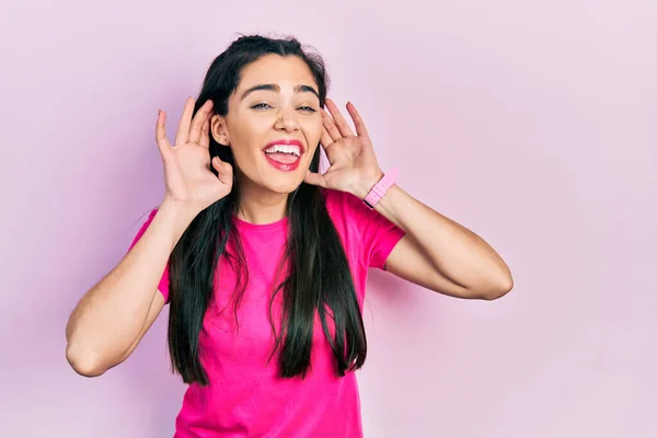 Νεαρή Ισπανίδα Που Φοράει Ροζ Μπλουζάκι Προσπαθώντας Ακούσει Και Δύο — Φωτογραφία Αρχείου