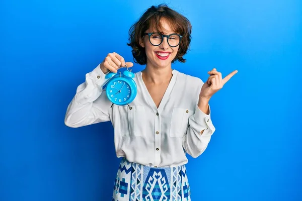 Jong Brunette Vrouw Holding Wekker Glimlachen Gelukkig Wijzend Met Hand — Stockfoto