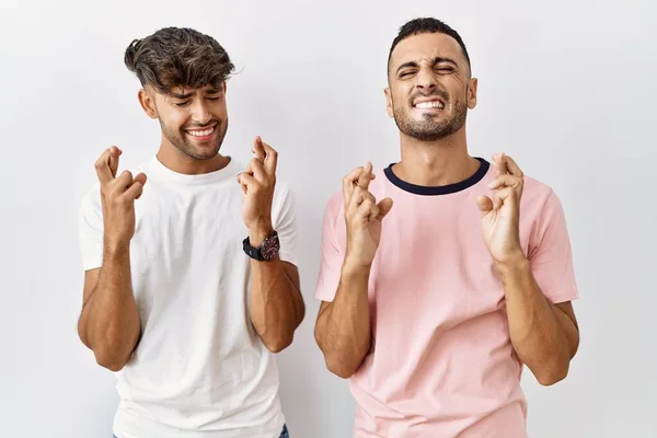 Jovem Casal Gay Sobre Fundo Isolado Gesto Dedo Cruzado Sorrindo — Fotografia de Stock