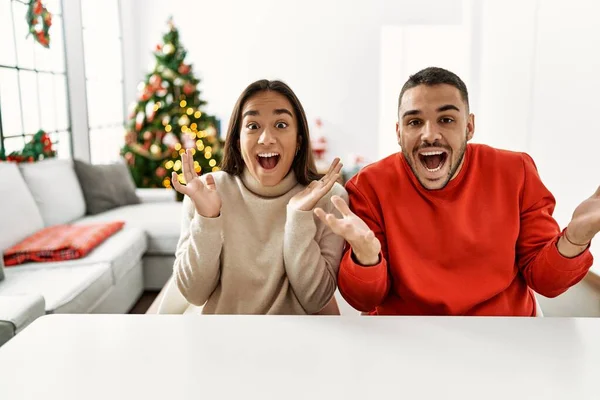 Jong Hispanic Paar Zitten Tafel Door Kerstboom Vieren Overwinning Met — Stockfoto