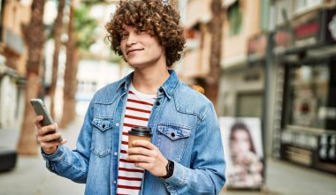 Genç İspanyol adam şehirde akıllı telefon kullanıyor.