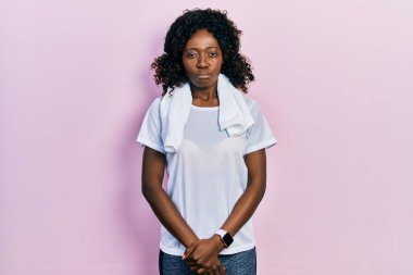 Genç Afro-Amerikalı kadın spor kıyafetleri ve havlu giyiyor. Depresyonda ve endişe içinde. Kızgın ve korkmuş bir şekilde ağlıyor. hüzünlü ifade. 
