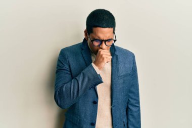 Zarif kıyafetler ve gözlük takan yakışıklı İspanyol adam kendini iyi hissetmiyor ve soğuk algınlığı veya bronşitin belirtisi olarak öksürüyor. sağlık hizmeti kavramı. 