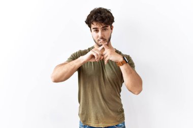 İzole edilmiş beyaz arka planda duran İspanyol bir adam. Reddedilme ifadesi negatif işaret veriyor. 