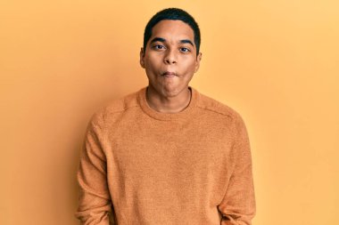 Gündelik kazak giyen genç, yakışıklı İspanyol adam dudaklarıyla balık suratı yapıyor, çılgınca ve komik bir hareket. Komik ifade. 