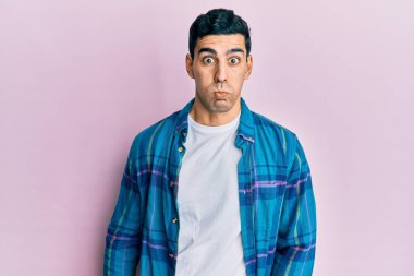 Sıradan kıyafetler giyen yakışıklı İspanyol adam komik yüzlü yanakları şişiriyor. Havayla şişmiş ağız, çılgın bir ifade.. 