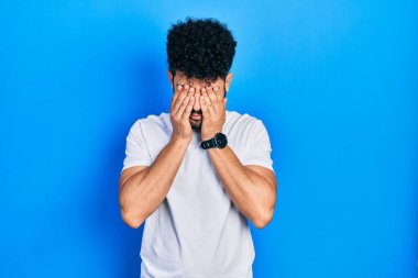 Sakallı, günlük beyaz tişörtlü, yorgunluk ve baş ağrısı için gözlerini ovuşturan, uykulu ve yorgun ifadeli genç bir Arap. görme sorunu 