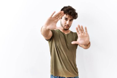 İzole edilmiş beyaz arka plan üzerinde duran İspanyol adam el ve parmakları kullanarak çerçeve yapıyor, kamera bakış açısı. 