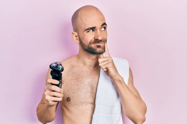 Tıraş bıçağı tutan kel bir adam. Ciddi bir yüzü var. Soru sorarken çenesi üzerine kafa karıştırıcı bir düşünce. 