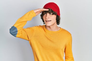 Yün şapka takan yakışıklı genç adam çok mutlu ve gülümsüyor. arama kavramı. 